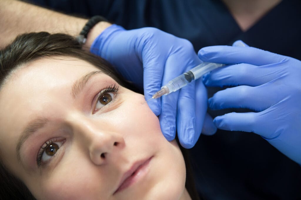 Woman getting filler injections for hollow under eyes and cheeks